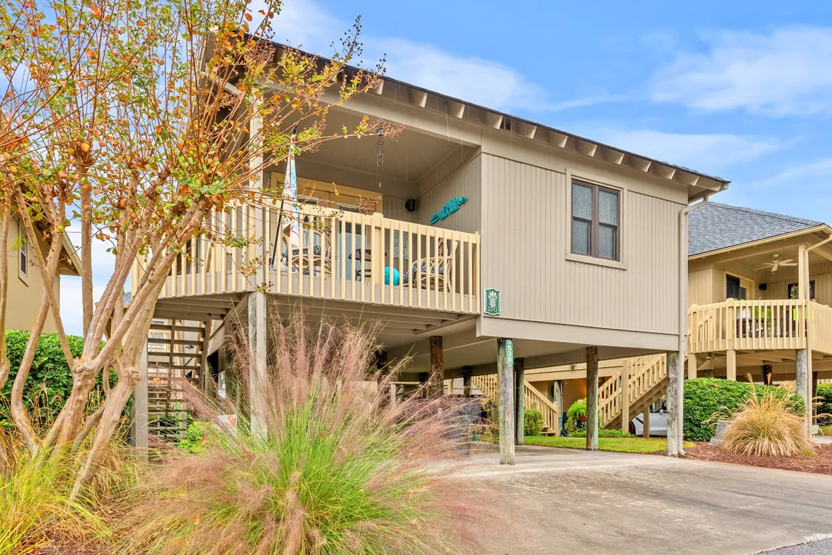 A welcoming deck with comfortable seating, colorful porch decor, and lush landscaping, this cottage exterior invites outdoor relaxation and gatherings just outside your door.